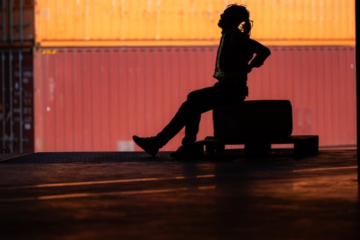 Warehouse worker's back pain from hard work while sitting and relaxing, Silhouette concept photo