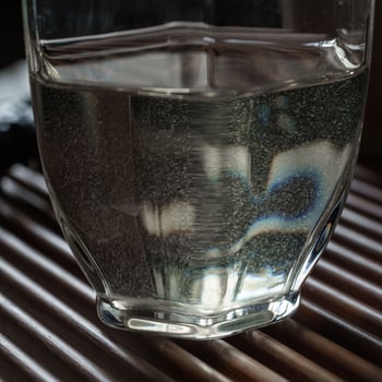 A Beautiful Glass Filled with Crystal Clear Water Placed Elegantly on a Wooden Surface photo