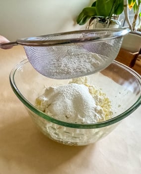 Sifting Flour Into Glass Bowl for Baking Preparation. High quality photo