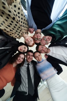 A diverse group of business professionals standing together in a powerful, united pose, captured from a low-angle perspective, exuding confidence and teamwork photo