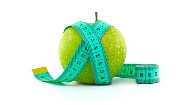 Green Apple with Measuring Tape for Health Isolated on White Background photo