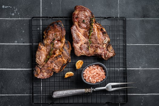BBQ Grilled Pork loin steaks, neck meat. Black background. Top view photo