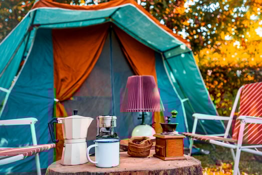 vintage coffee set on the old wooden table In front of the retro cabin tent, retro chairs, Group of camping tents, and soft focus. photo
