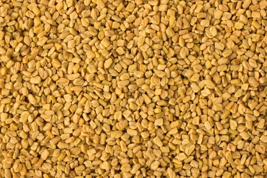 fenugreek seed spice as a background, natural seasoning texture photo