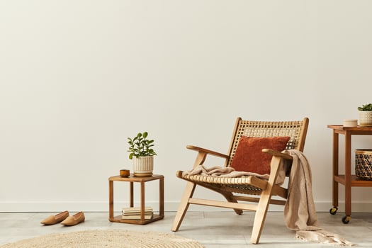 Neutral concept of living room interior with design wooden armchair, round carpet, dried flowers in vase, slippers, decoration and elegant personal accessories. Template. Copy space. photo