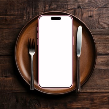 Pink smartphone mockup template with blank screen on plate with knife and fork photo