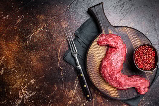 Raw Skirt Machete beef meat steak on wooden board. Dark background. Top view. Copy space photo