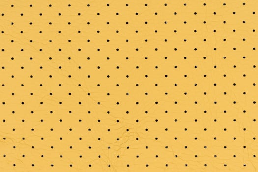 Yellow color abstract artificial leather with small dots and holes pattern for background photo