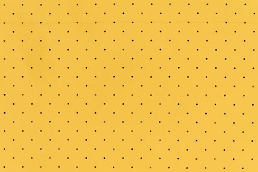 Yellow color abstract artificial leather with dots and holes pattern for background photo