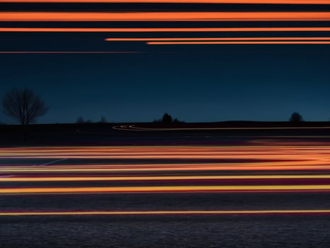 orange car lights at night on road long exposure. photo