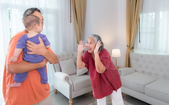 Grandparents and their little grandchild play happily in the living room of the house photo