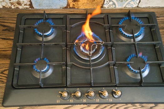 Cooking on a gas stove with flames and blue burners in a kitchen photo