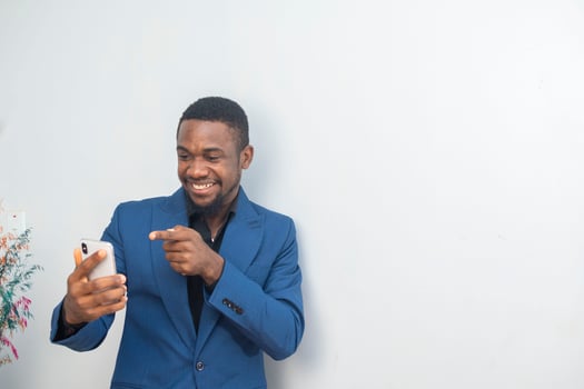portrait of cheerful young black guy sending message on mobile phone. Happy African-American man using smartphone, enjoying chatting online, messaging in social networks photo