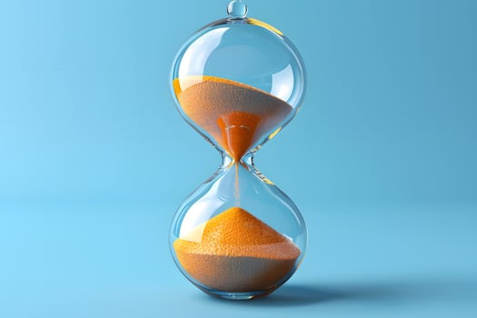 Elegant Hourglass with Flowing Sand on a Blue Background for Time Concept photo