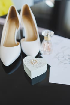 Accessories of the bride. Wedding shoes for the bride. White high-heeled shoes near wedding rings, wedding jewelry. photo
