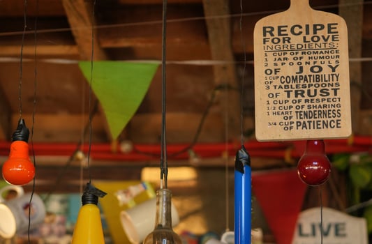 a sign hanging from a ceiling with a bunch of different colored lights photo