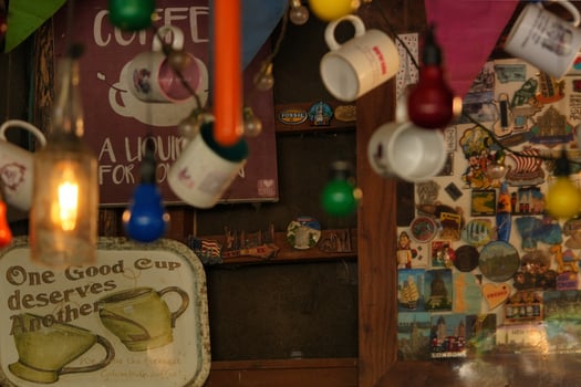 a coffee shop with a lot of coffee cups and a sign photo