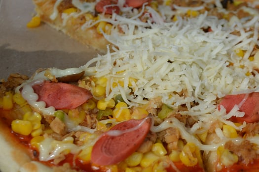 Delicious pizza with topping sausages, cheese, and corn, delicious meal to eat photo