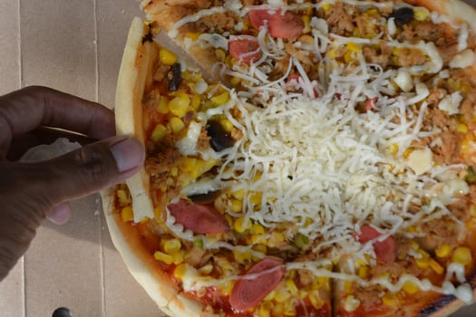 Delicious pizza with topping sausages, cheese, and corn, delicious meal to eat photo