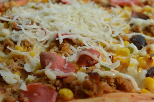 Delicious pizza with topping sausages, cheese, and corn, delicious meal to eat photo