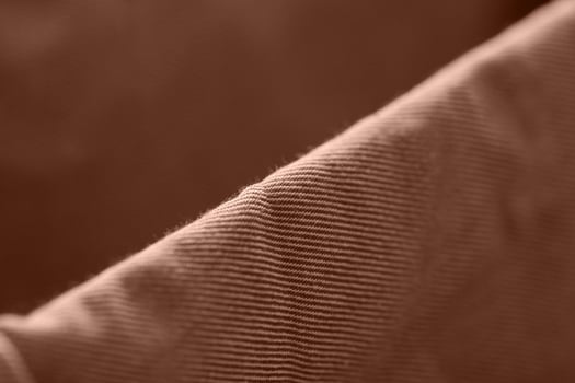 Close up of brown corduroy fabric with detailed ribbed texture in soft lighting. photo
