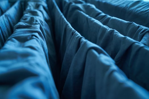 Close up of blue fabric folds with intricate textures and play of light and shadow. photo