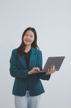 Attractive elegant young asian business woman using digital tablet standing on isolated background. Happy young latin female formal black suit holding tablet gadget working service with customer photo