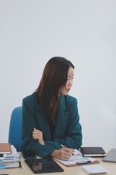 Asian professional businesswoman working on tablet computer in a corporate office photo