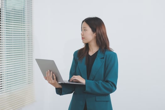 Attractive elegant young asian business woman using digital tablet standing on isolated background. Happy young latin female formal black suit holding tablet gadget working service with customer photo