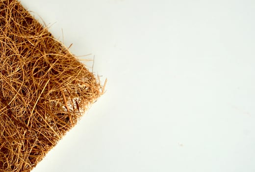 Brown scrubber tool from coconut heap textures isolated on horizontal empty copy spaced white background. photo
