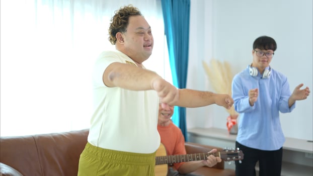 A family with an autistic child enjoys singing and dancing together at home during the holidays photo