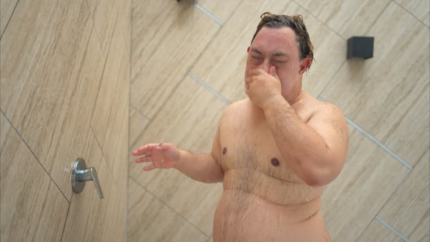 Young man gets wet before swimming in pool photo