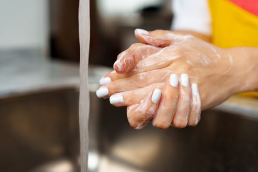 Close up of a woman washing her hands in a kitchen sink photo