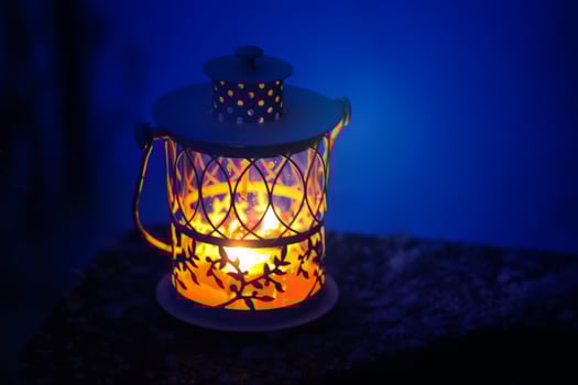 Decorative Christmas lantern with burning candle hanging on snow-covered fir- tree branch in a winter park. New year festive card, poster, postcard design. photo