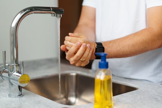 Man washing hands with soap in a sink at his home photo