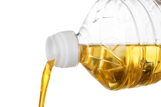 Pouring oil for cooking in a bottle isolated on white background. photo