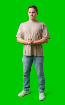 A young man stands confidently in casual attire on a vibrant green background photo