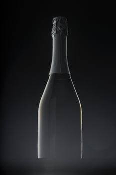 Champagne bottle on black background, copy space photo