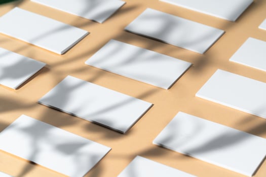 Creative photo with floral shadow of white businesscard on beige background