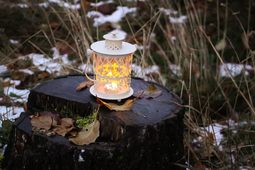 Decorative lantern with burning candle in autumn park at evening. photo
