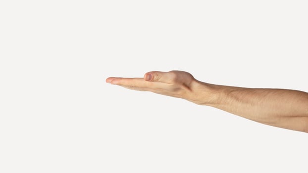 Millennial man displaying something against light background, close up. Empty space for design photo