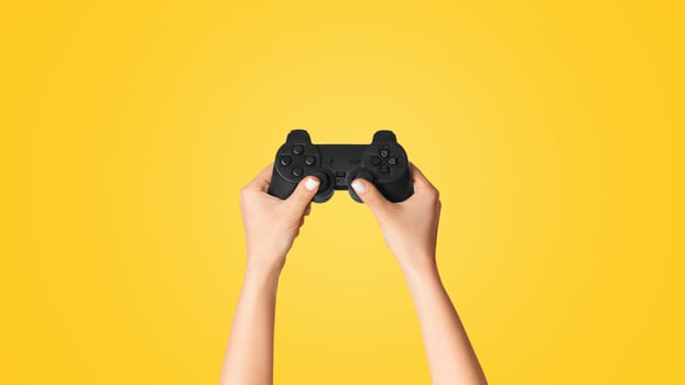 Fun hobbies concept. Woman holding game joystick on pink background, closeup. Panorama photo