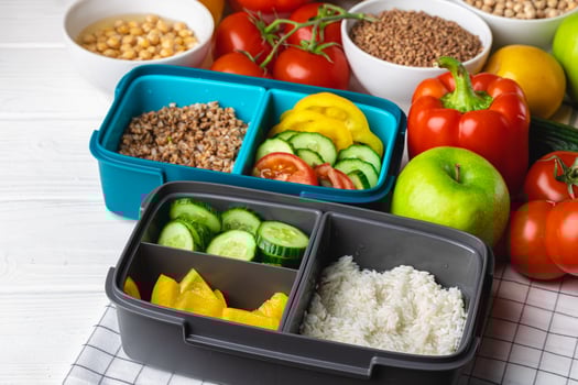 Lunch box with cooked buckwheat and fresh vegetable salad photo