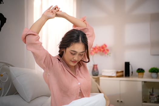 Asian young woman relaxing before bedtime on the bed in the bedroom photo