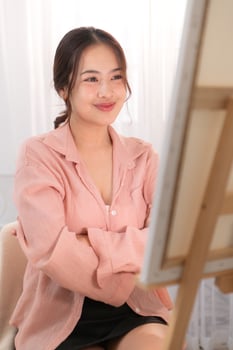 Asian young woman enjoying the happiness of painting photo