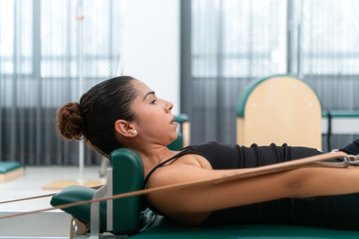 A young woman doing pilates exercises on a pilates reformer photo