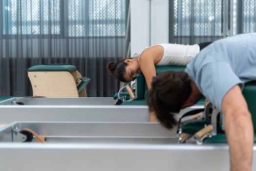 A young man and a young woman are doing pilates exercises on a pilates reformer photo