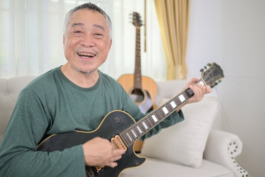 Senior man a veteran guitarist plays the old electric guitar at home photo