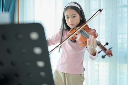 A girl violinist plays and practices the violin at home photo