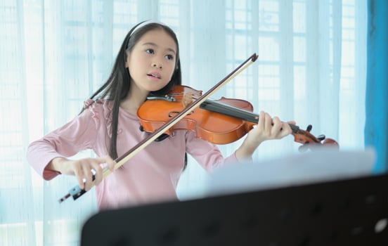 A girl violinist plays and practices the violin at home photo